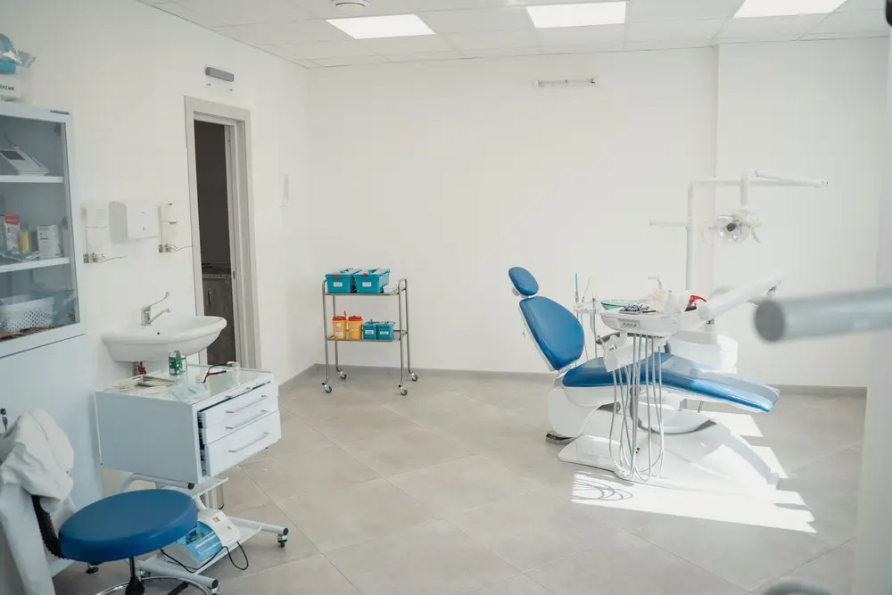 Bright, clean dental clinic room with a blue chair