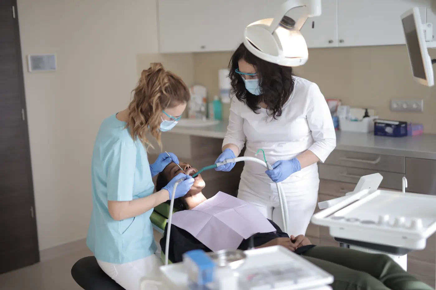 A dentist and assistant treating a patient in a bright, modern clinic