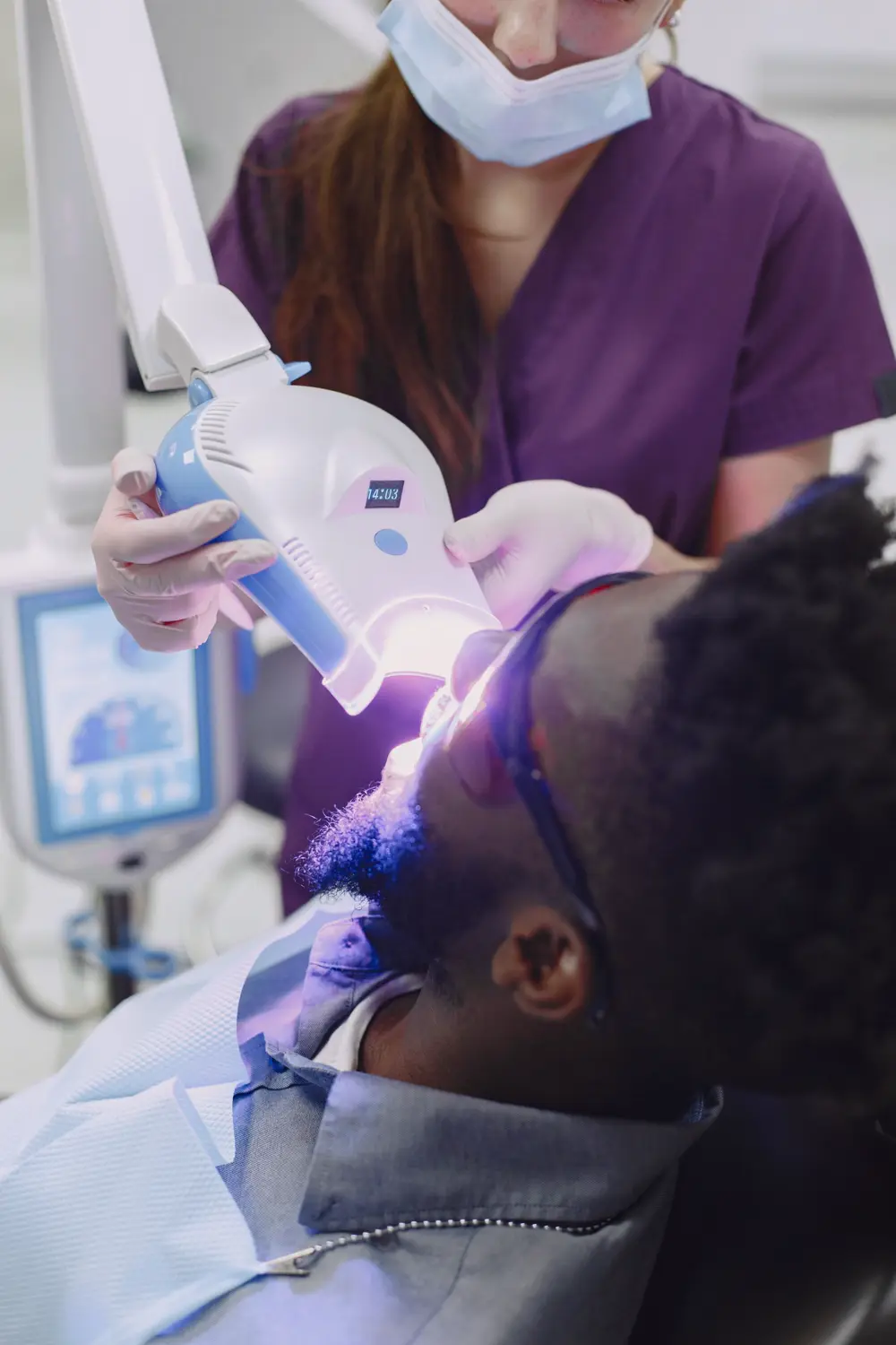 Close-up of a dental professional using a curing light