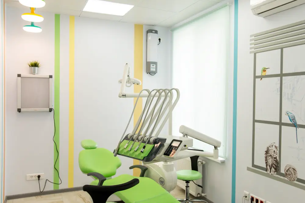 Bright dental treatment room with a green chair